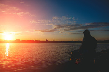 Naklejka na ściany i meble fantastic landscape,colorful sky over the lake. majestic sunrise. Fishing feeder at sunset. Fisherman silhouette at sunset. 