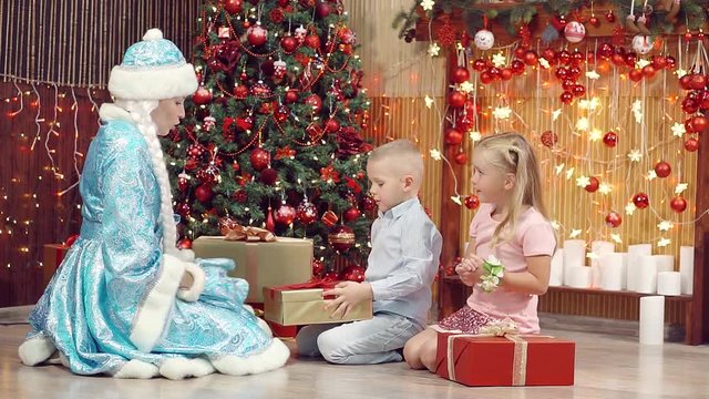 The boy and the girl choose Christmas gifts and assistant of Santa Claus.