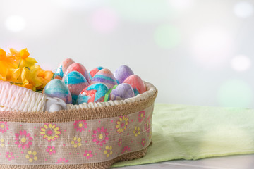 Basket of Hand Painted Easter Eggs with Daffodils on Table Horizontal with Copy Space & Bokeh