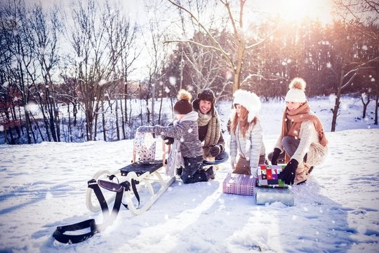Composite image of family playing with sled on snowy field