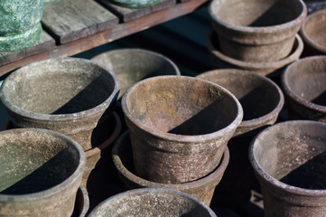 Vintage clay flower pots on wooden shelf, closeup