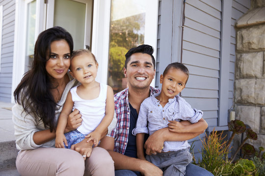 Portrait Of Family Sitting On Steps Outside Home