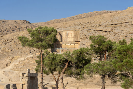Iran, northern Shiraz, Persepolis (Takht-e-Jamshid - the throne of Jamshid): Old tomb with trees in the late afternoon.