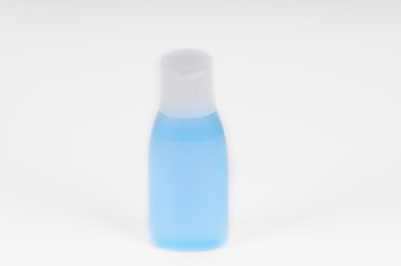 Small plastic vial bottle filled with the blue liquid isolated over the white background