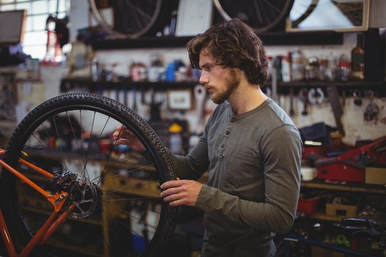 Mechanic examining a bicycle wheel