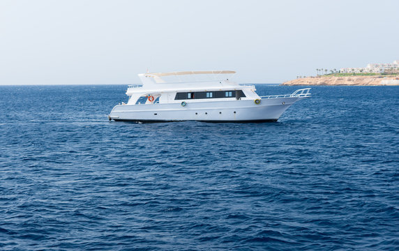 View of the sea with white floating yacht