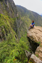 Fototapeta na wymiar Young woman enjoying the view of Inca Bridge and cliff path near