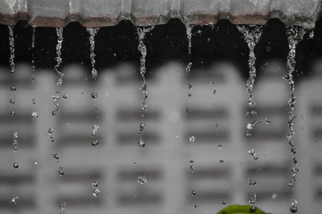 Blur blurred, Motion drop of water rain from roof at night,