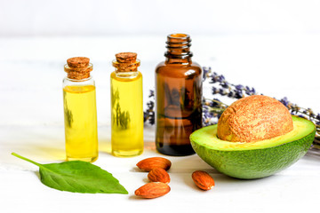 avocado oil for handmade cosmetics with herb on wooden background