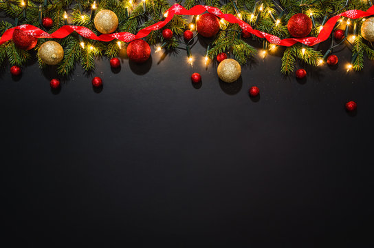 Christmas decoration background over black chalkboard, top view. Horizontal photo of decorations taken from above with copy space for text and other web or print design elements.
