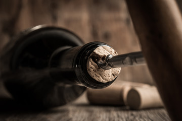 Corkscrew and bottle of wine on board - 127123383