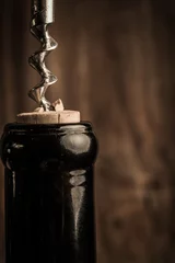 Fotobehang Bottle of wine and corkscrew over wooden background © poplasen