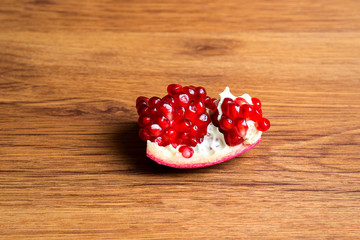 Pomegranate slices and garnet fruit seeds on table. Pomegranate whole. Useful fruit.