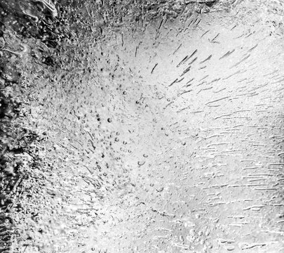 Micro air bubbles in the ice frozen during their movement to the water surface. 1 : 1 macro lens shot. BW photo.