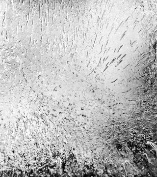 Micro air bubbles in the ice frozen during their movement to the water surface. 1 : 1 macro lens shot. BW photo.