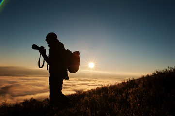 Silhouette of man photographer with camera on hand background mo