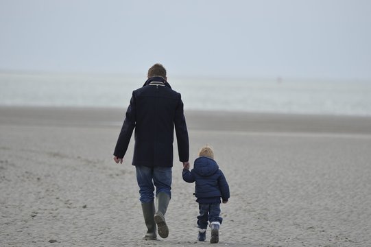 promenade sur la plage père et son enfant se donnant la main
