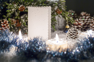 Christmas still life is with snow. White plate for congratulations is near the Christmas tree.  