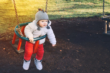 Portrait of cute baby on swing, outdoors.