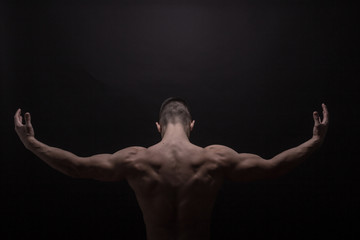 young man posing back muscles, rear view