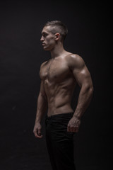 Fototapeta na wymiar young man, bodybuilder posing, side view, profile