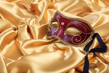Carnival mask isolated on golden satin background, copy space