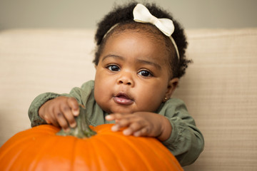 Cute baby girl with a  pumpkin.