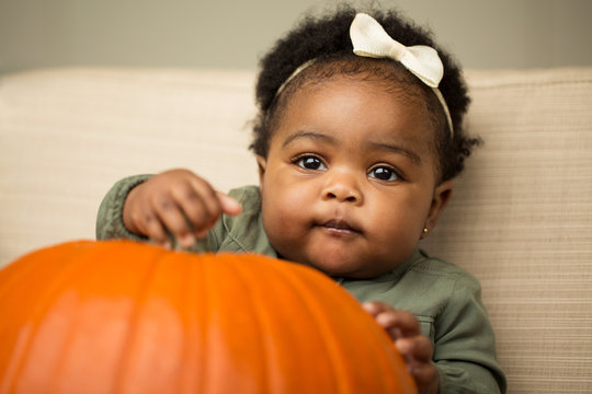 Cute baby girl with a  pumpkin.