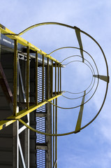Naklejka premium Caged ladder leading up and blue sky