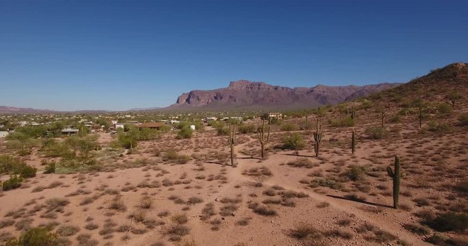 A flyover aerial establishing shot of Superstition Mountain in the desert of Arizona.  	