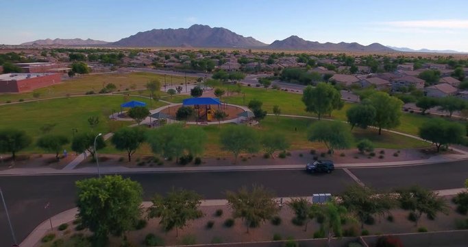 A daytime aerial establishing shot of a typical Arizona neighborhood park.  	