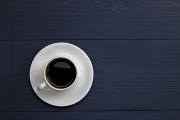 Cup of coffee on the wooden table in blue