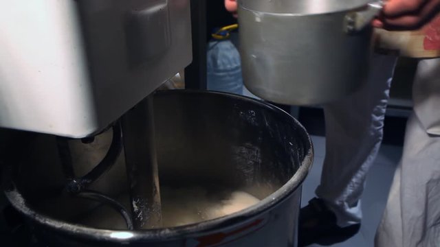 Bread Mixer In Bakery, mixing dough for baguettes in a bakery machine for mixing dough, top view