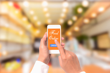 Hand holding mobile with Order food online with blur restaurant