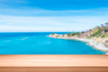 Wood table top on blurred blue sea background - can be used for