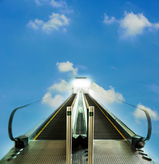 Escalator walkway leading up to bright light with blue sky, concept of way to success or heaven
