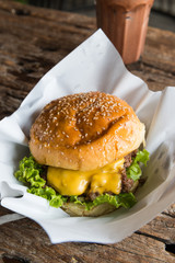 Homemade beef burger with melted cheese  on wooden background