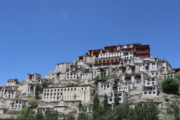 Obraz premium Thiksay Tibetan Buddhist monastery is located on top of a hill in Thiksey village, near Leh in Ladakh, India. Visitors reguraly come to pray here.