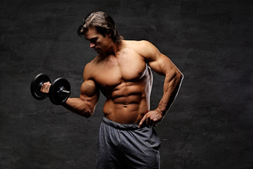 Fototapeta na wymiar Shirtless muscular male holds dumbbell.