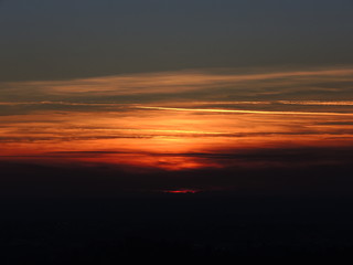 Fiery sunset from Bergamo city to the Padana valley. Lombardy, Italy. Sunset during fall season.