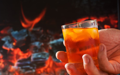 glass of drink in his hand