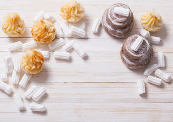 white marshmallows with cakes  on wooden background