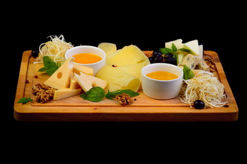 Wooden cheese plate on black background