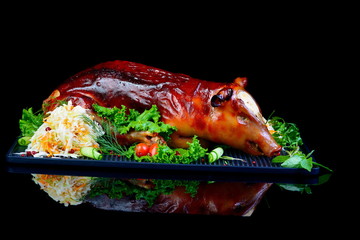 baked piglet on black background © Vitaliy