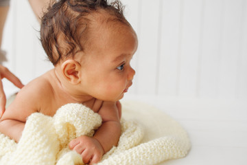 Newborn baby on stomach looking aside, free space on white. Adorable little child interested of something. Background for children care and development products