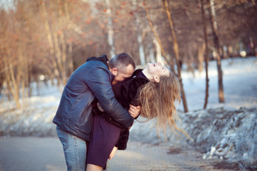 The man tightly hugs the woman, she laughs, tilting his head back, spring, Park.