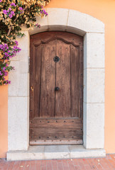 Fototapeta na wymiar Old wooden door in the entrance stone French house