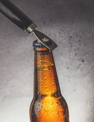 fresh cold beer ale bottle with drops and stopper open with bottle opener