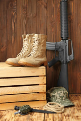 Set of military outfit on wooden background