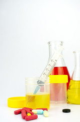 Social Issue Concept - Urine sample bottle, pills and syringe isolated on a white background with shallow depth of field (dof)